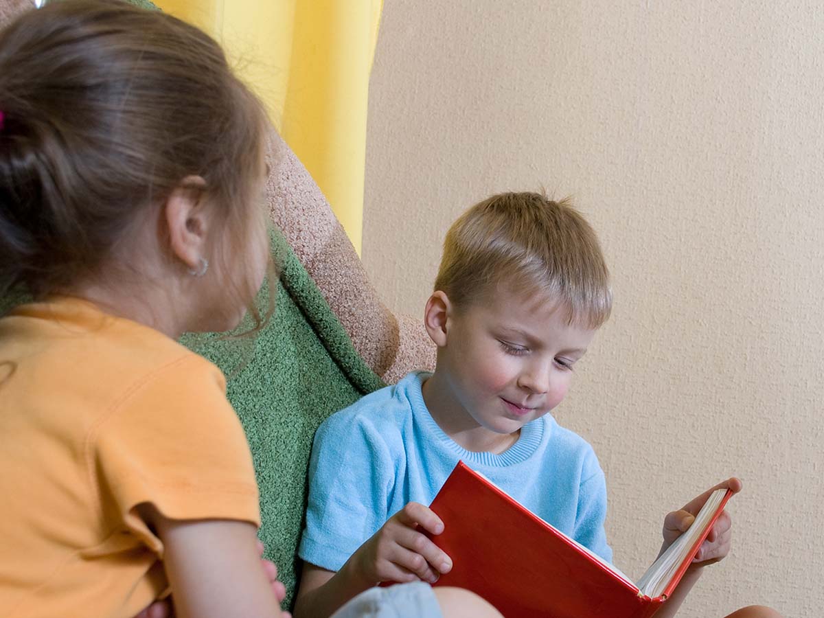 a young boy reading a book to his new friend