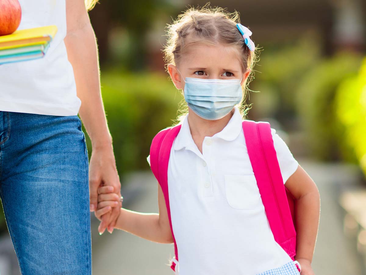 a teacher holding the hand of a young student