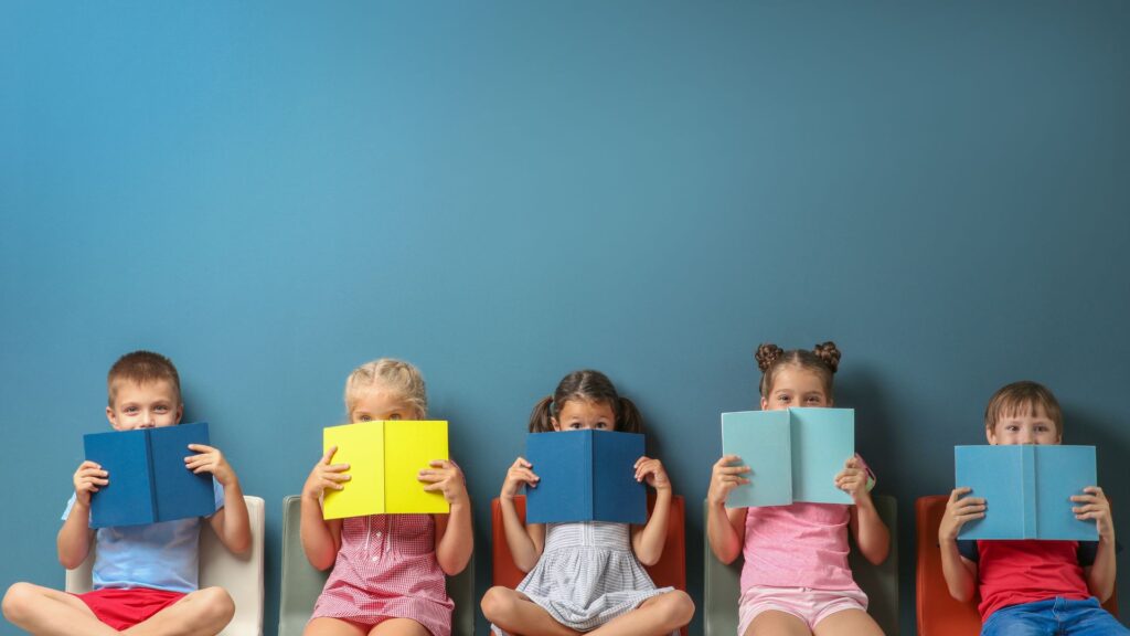 kids reading on chairs with a blue background