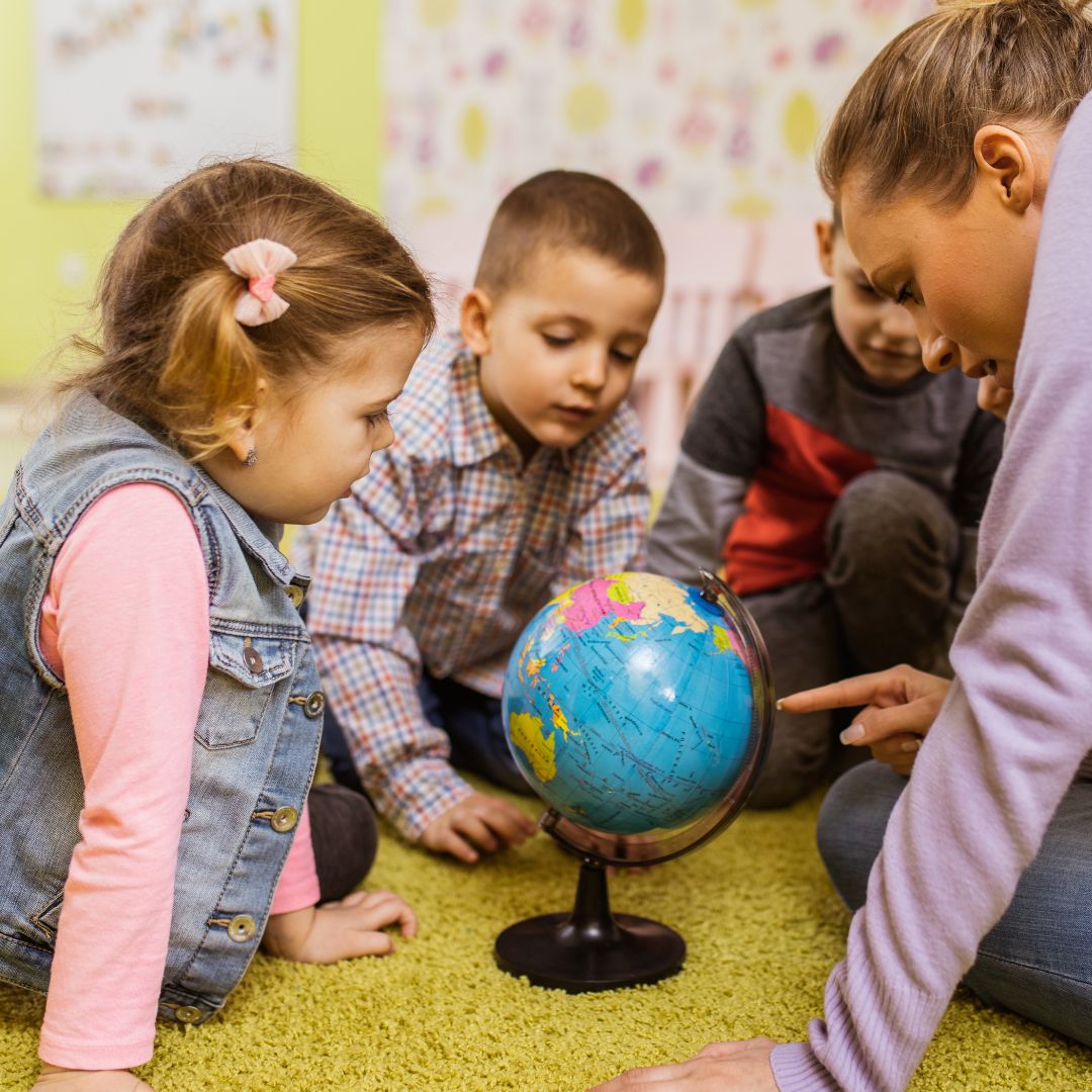 preschool kids looking at globe