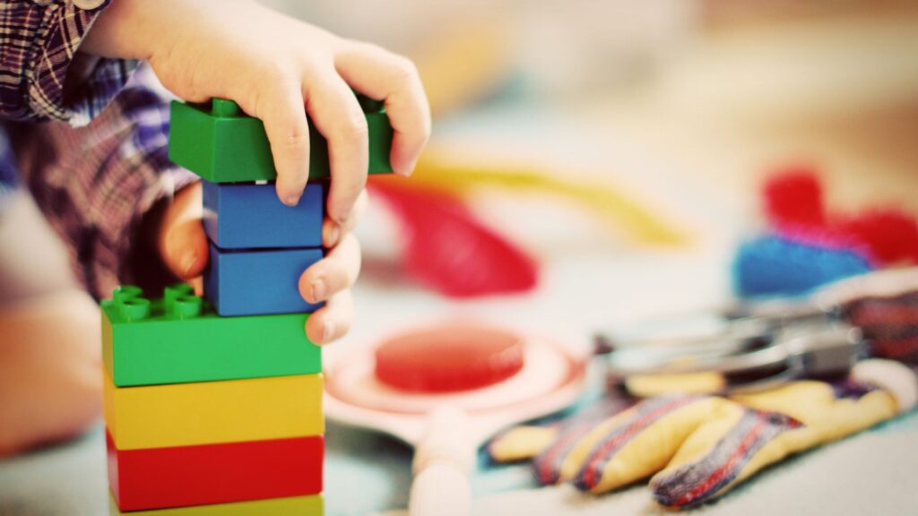 a child stacking colored blocks
