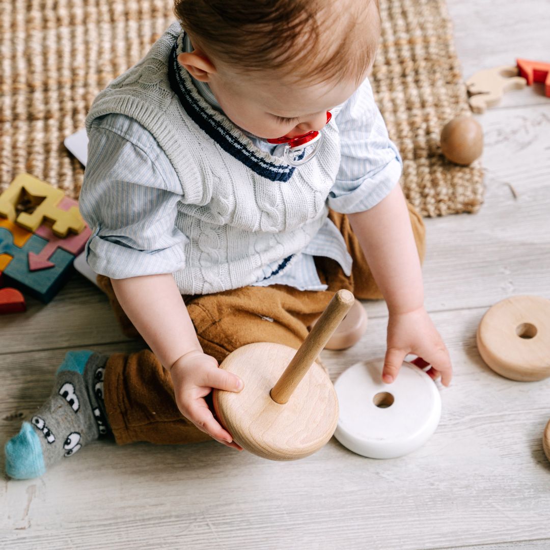 An infant plays with toys