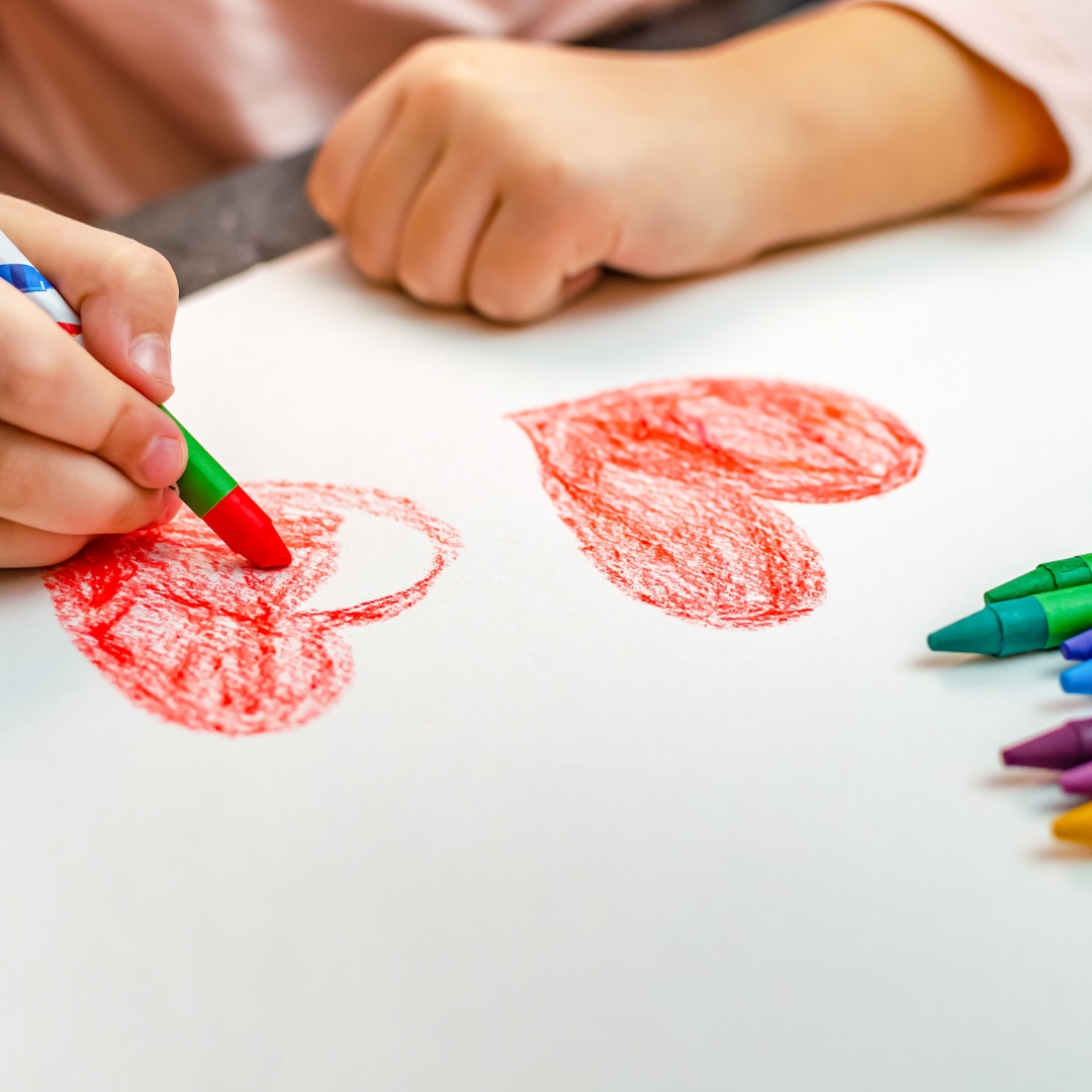 image of a kid drawing hearts