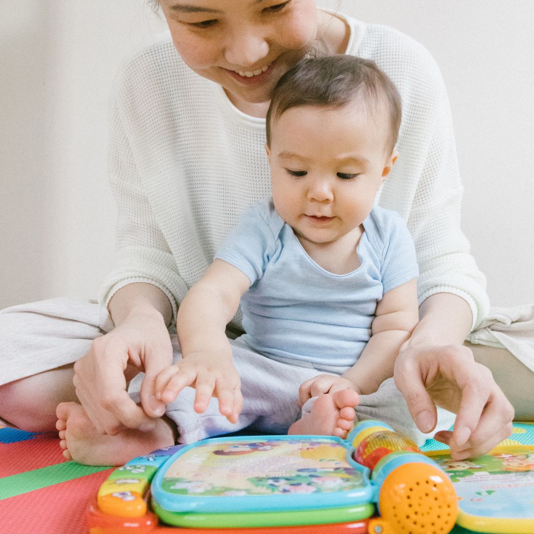 an infant playing with an interactive book