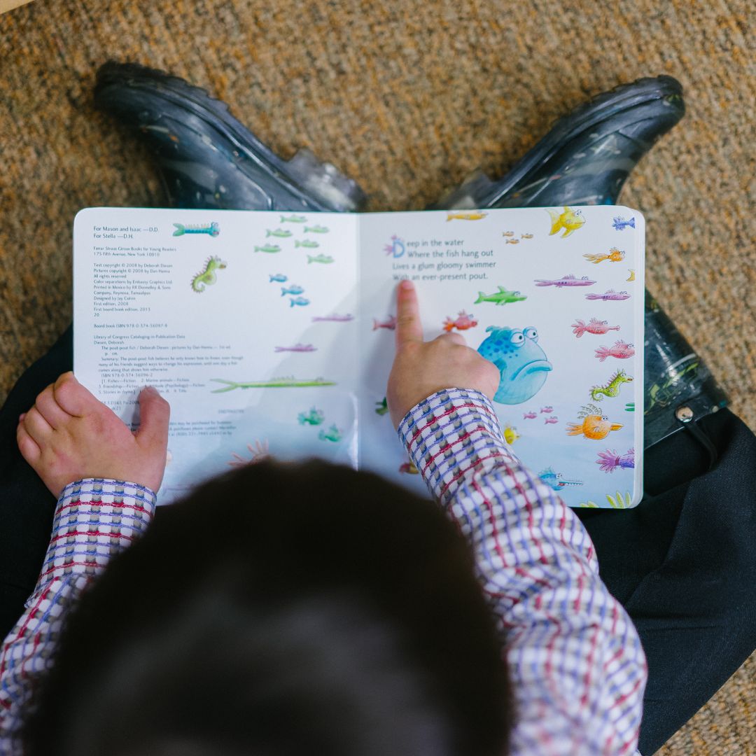 a child pointing at words in a book
