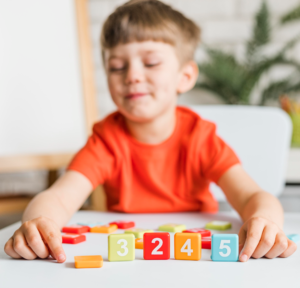 A toddler practices counting by arranging colorful numbered wooden blocks.