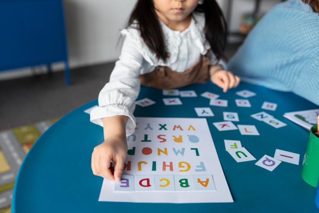 A high-angle view of a child sitting on a rug while organizing colorful wooden alphabet blocks.