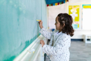 A child writing on a blackboard