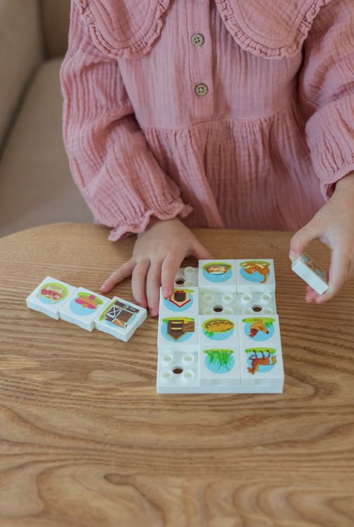  Young child exploring a colorful educational puzzle during independent play.