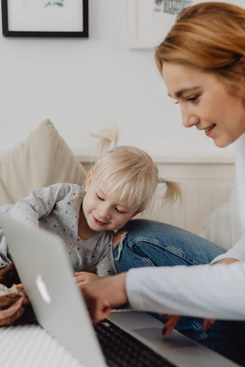 Mother and daughter looking at a laptop together at home